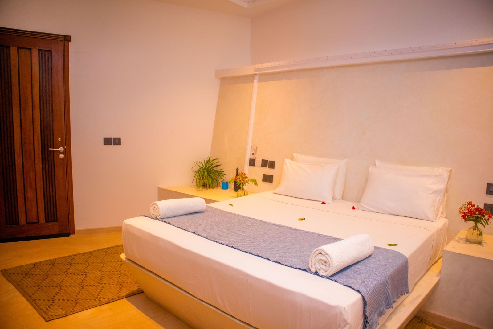 King bedroom dressed with a blue runner and fresh flowers