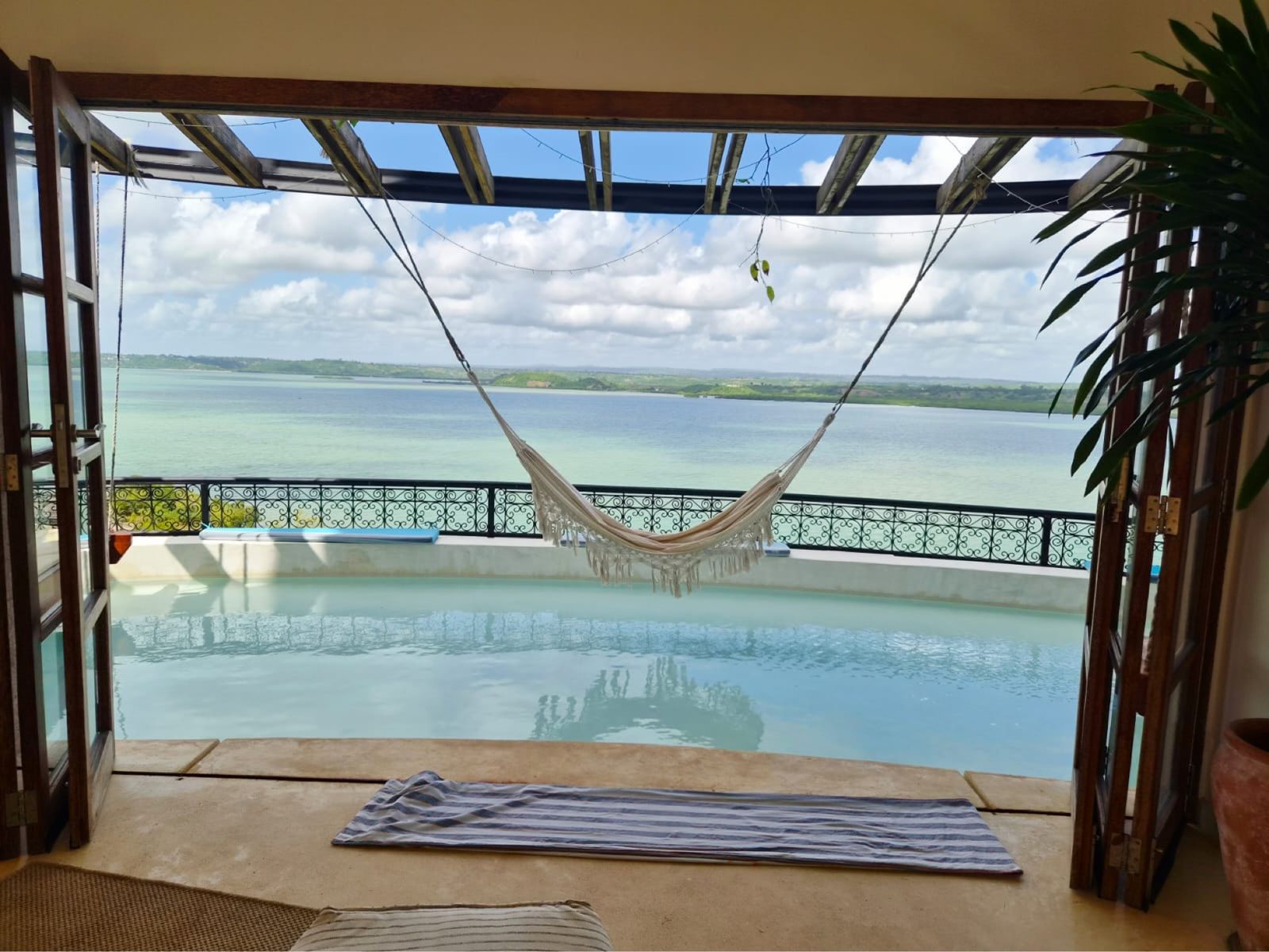 Hammock strung over the pool terrace, the creek beyond